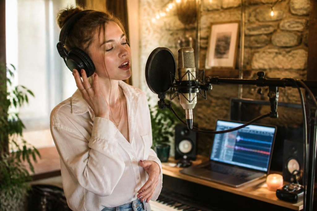 Singer recording layered vocal harmonies in a home studio.