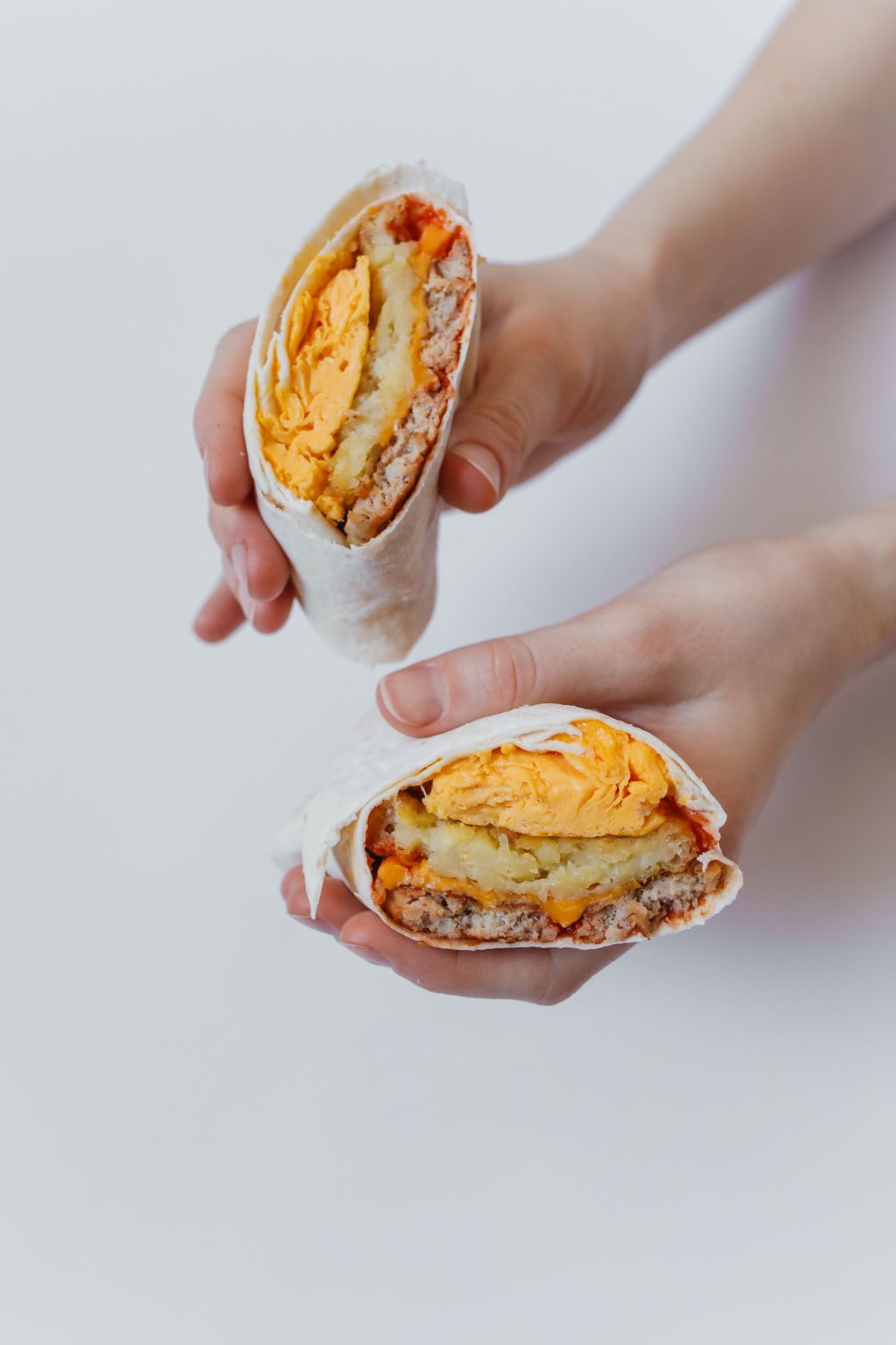 Breakfast burrito halves filled with eggs and potatoes.