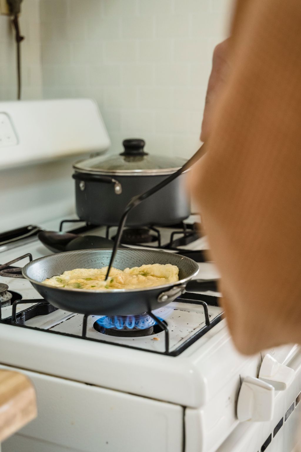 Scrambled eggs being cooked in a frying pan for breakfast.